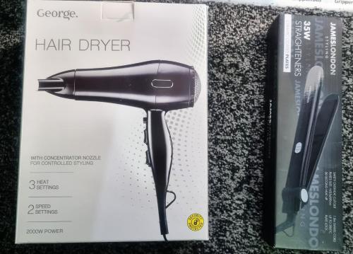 a hair dryer in a box next to a book at -RE15CFA- For Relaxed and Cosy stay with Free Parking in Leeds