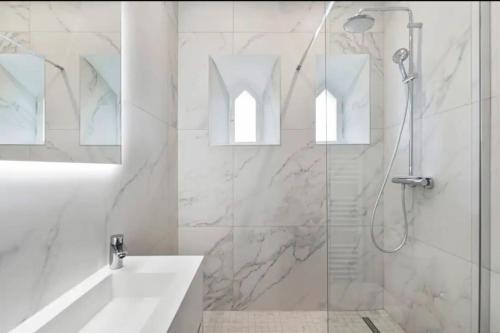 une salle de bain blanche avec une douche et un lavabo dans l'établissement 3 bedrooms 3 bath Bivouac 2 min Palais, à Cannes