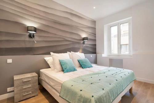 - une chambre avec un grand lit et un mur rayé dans l'établissement 3 bedrooms 3 bath Bivouac 2 min Palais, à Cannes