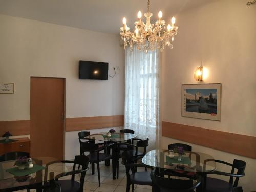 Un comedor con mesas y sillas y una lámpara de araña. en Pension Ani, en Viena
