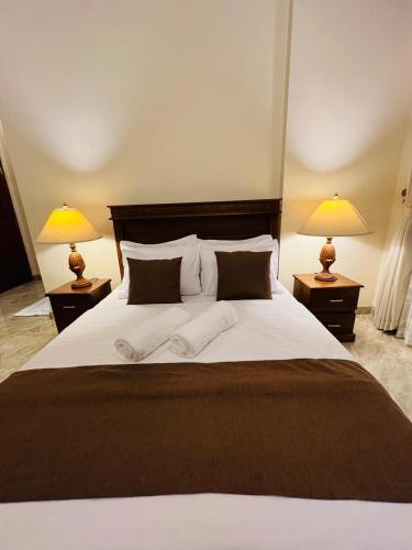 a bedroom with a large bed with two lamps at Uyana View in Moratuwa
