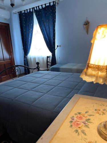 a bedroom with a large blue bed with a window at Villa Russo in Caltanissetta