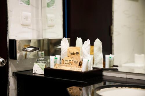 a bathroom counter with toiletries and a mirror at Anwar Al Madinah Mövenpick in Al Madinah