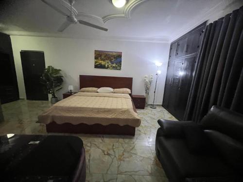 a bedroom with a bed and a couch at NESTA BARRON -Home Away from Home in North Legon