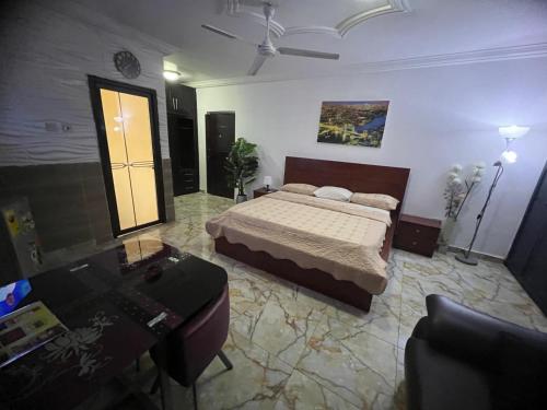 a bedroom with a bed and a desk in it at NESTA BARRON -Home Away from Home in North Legon