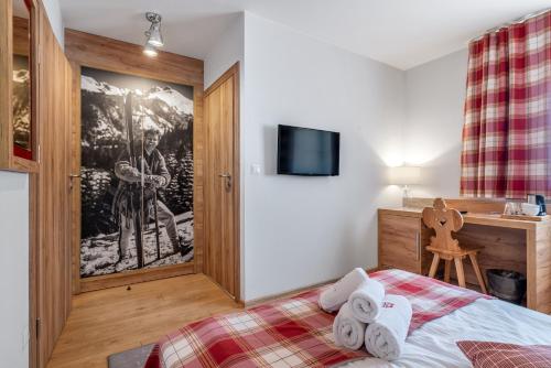 a bedroom with a bed with towels on it at Parzenica B&B - Wyjątkowa i Jedyna!!! Sprawdź nas a nie pożałujesz! in Białka Tatrzanska