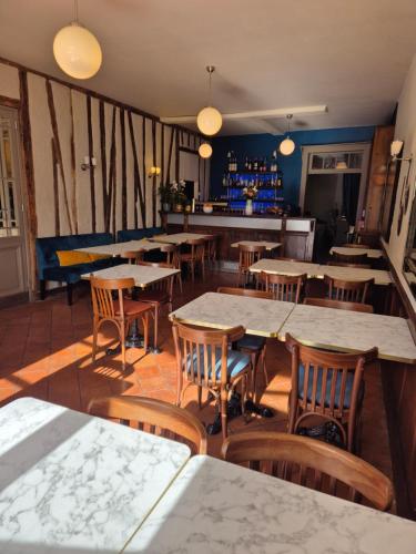 a restaurant with tables and chairs and a bar at Le Saint-Laurans in Aurignac