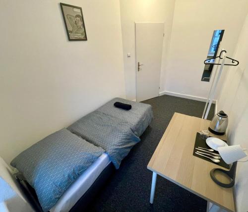 a small bedroom with a bed and a table at Fantastic-Inn Warszawa - Chmielna in Warsaw