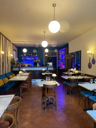 un restaurant avec des tables et des chaises et un bar dans l'établissement Le Saint-Laurans, à Aurignac