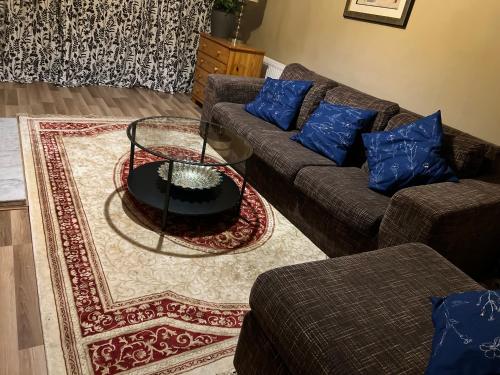 a living room with two couches and a table at Cosy 3 bed bungalow in Dublin in Lucan