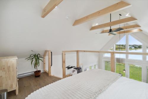ein Schlafzimmer mit einem Bett und einem großen Fenster in der Unterkunft Harbour View Loft at Bells Cove in Shelburne