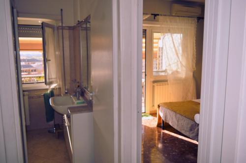 a bathroom with a sink and a bed with a window at Appia Sweet Home in Rome