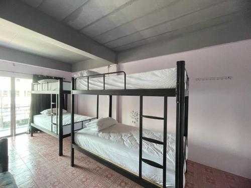 a bedroom with two bunk beds in a room at Bed & Breakfast Pattaya in Pattaya