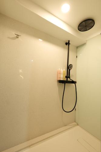 a room with a shower with a shower head at Aster Apartment Bali in Canggu