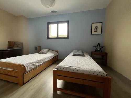 une chambre avec deux lits et une fenêtre dans l'établissement Villa piscine privée à 20 min des plages 10RDH21, à Peyrestortes
