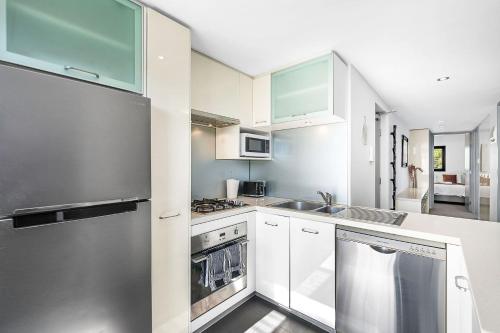 a kitchen with white cabinets and stainless steel appliances at More Room, Up Top A Sepal Stay in Perth
