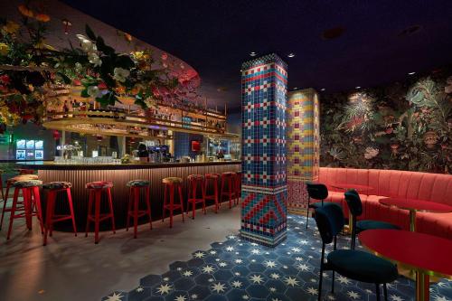 a bar with red chairs and a colorful pillar in a restaurant at NH Collection Amsterdam Flower Market in Amsterdam