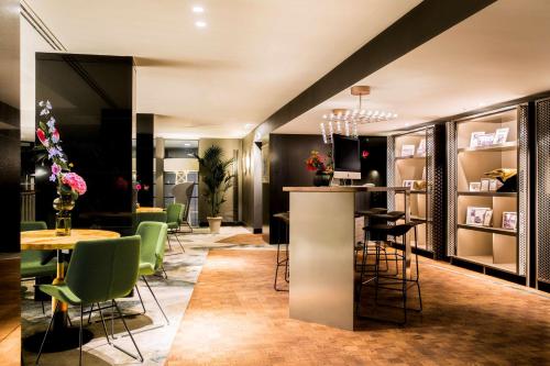 a restaurant with a bar with chairs and tables at NH Collection Amsterdam Flower Market in Amsterdam