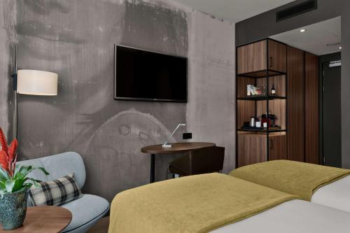 a hotel room with two beds and a tv at NH Collection Amsterdam Flower Market in Amsterdam