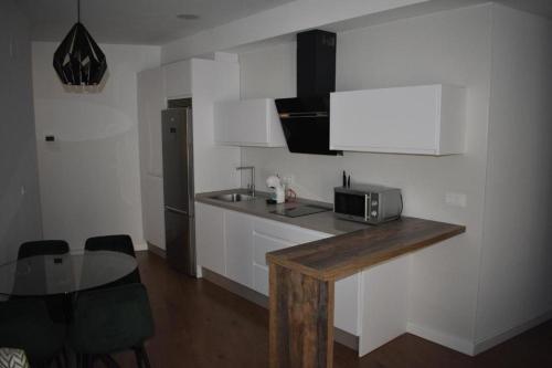 a kitchen with a counter with a microwave and a table at Apartamentos Molinos in Constantina