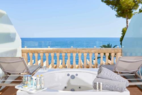 a bath tub with two chairs and a balcony with the ocean at Barceló Illetas Albatros - Adults Only in Illetas