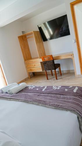 a room with a bed and a chair and a mirror at Hospedaje La Angostura in Ica