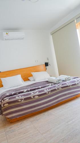 a bedroom with a large bed with a wooden headboard at Hospedaje La Angostura in Ica