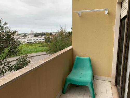 a green chair sitting on the ledge of a balcony at Discovery Apartment Carnaxide in Carnaxide