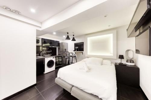 Cet appartement comprend une chambre avec un lit blanc et une cuisine. dans l'établissement Saint Michel, à Paris
