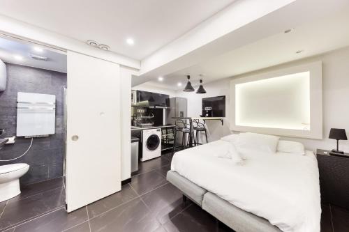 une chambre avec un lit blanc et une salle de bain dans l'établissement Saint Michel, à Paris