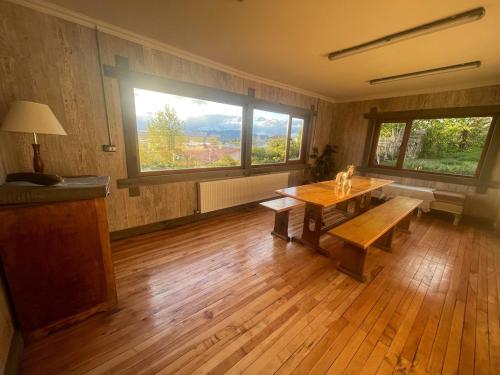a room with a wooden table and a large window at Casa Oxidada in Puerto Natales