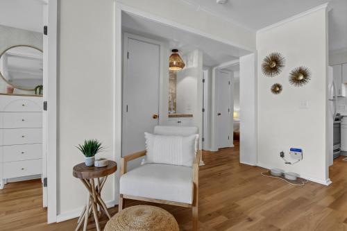 a white living room with a chair and a table at After Dune Delight by Sea Scape Properties in Carolina Beach
