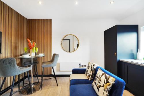 a living room with a blue couch and a table at Boutique and Beautiful Flat in Yorkshire - Top Floor in Castleford