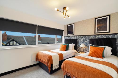 two beds in a room with a large window at Boutique Penthouse in Yorkshire - Top Floor in Castleford