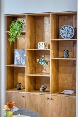 a wooden book shelf with a clock on it at Le 18 Prévost - Square in Fontaine