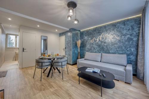 a living room with a couch and a table at Le 18 Prévost - Square in Fontaine