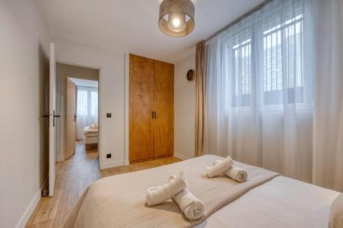 a bedroom with a large bed with towels on it at Le 18 Prévost - Square in Fontaine