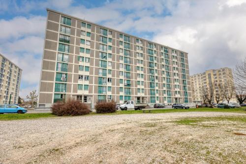 a large building with cars parked in front of it at Le 18 Prévost - Square in Fontaine
