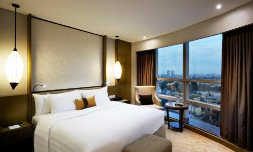 a hotel room with a bed and a large window at Melia Hanoi in Hanoi