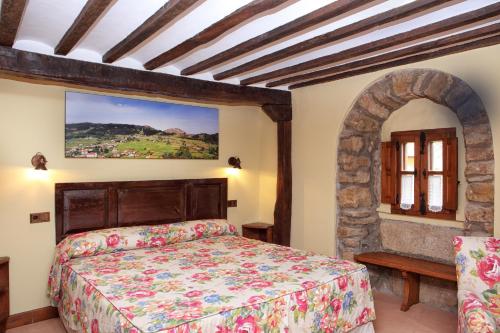 a bedroom with a bed and a painting on the wall at Posada La Torre de La Quintana in Liendo
