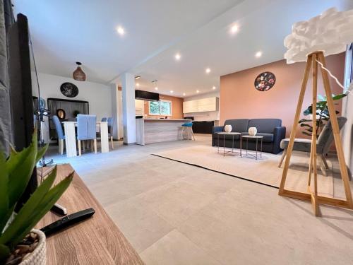 un salon avec une cuisine et une salle à manger dans l'établissement Maison Neuve 9 personnes Terrasse & Garage Privé, à Besançon