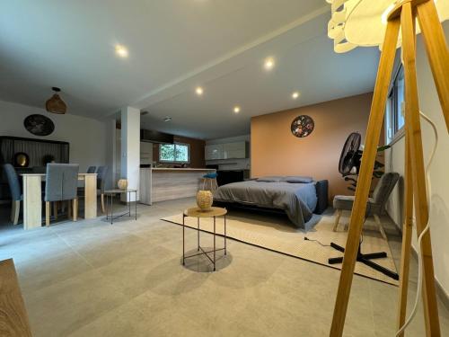 a bedroom with a bed and a kitchen and a table at Maison Neuve 9 personnes Terrasse & Garage Privé in Besançon