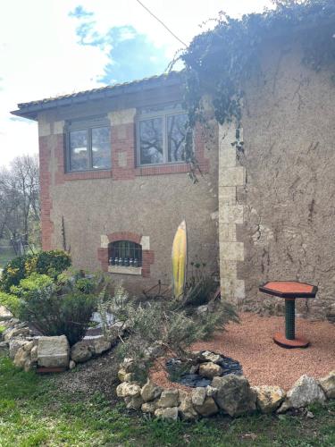 a house with a table in front of a yard at Maison Atypique dans le Gers avec activités in Pavie