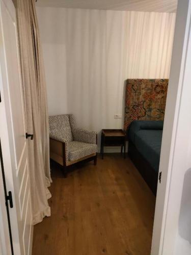 a bedroom with a bed and a chair and a chair at Apartamentos Molinos in Constantina