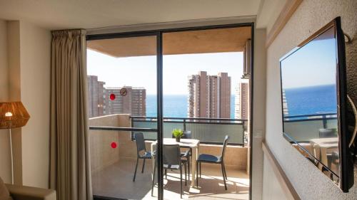 a room with a balcony with a table and chairs at Dynastic Rooms Apartments in Benidorm