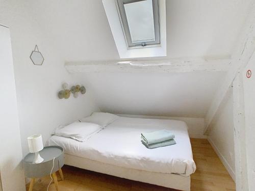 a small bed in a small room with a window at Le Perchoir in Melun