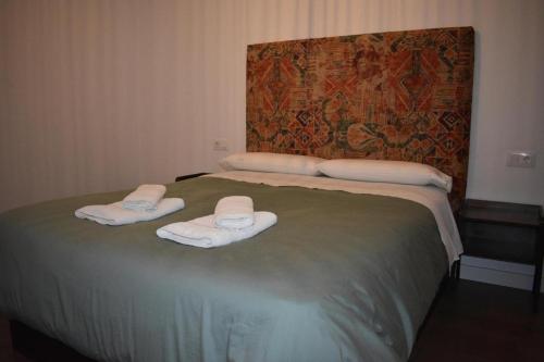 a bedroom with a bed with towels on it at Apartamentos Molinos in Constantina