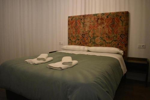 a bedroom with a bed with towels on it at Apartamentos Molinos in Constantina