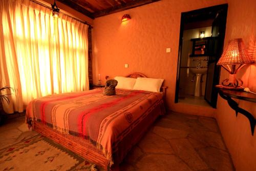 a cat sitting on a bed in a bedroom at Peace Eye Guest House in Pokhara