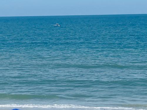 a boat in the middle of a large body of water at 2 bedroom garden city ocean front in Myrtle Beach